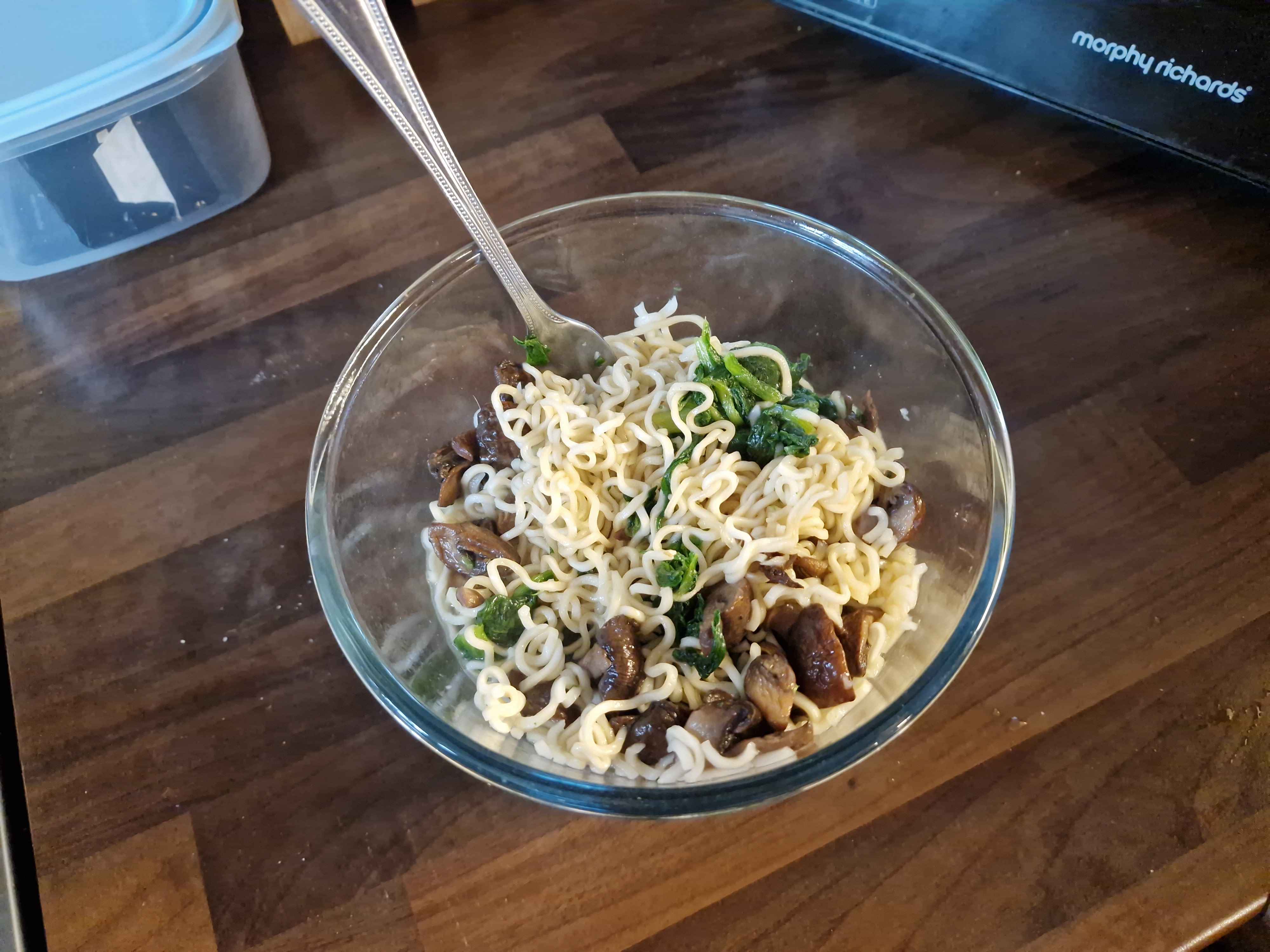 The prepared bowl of noodles, with bits of mushroom and spinach.