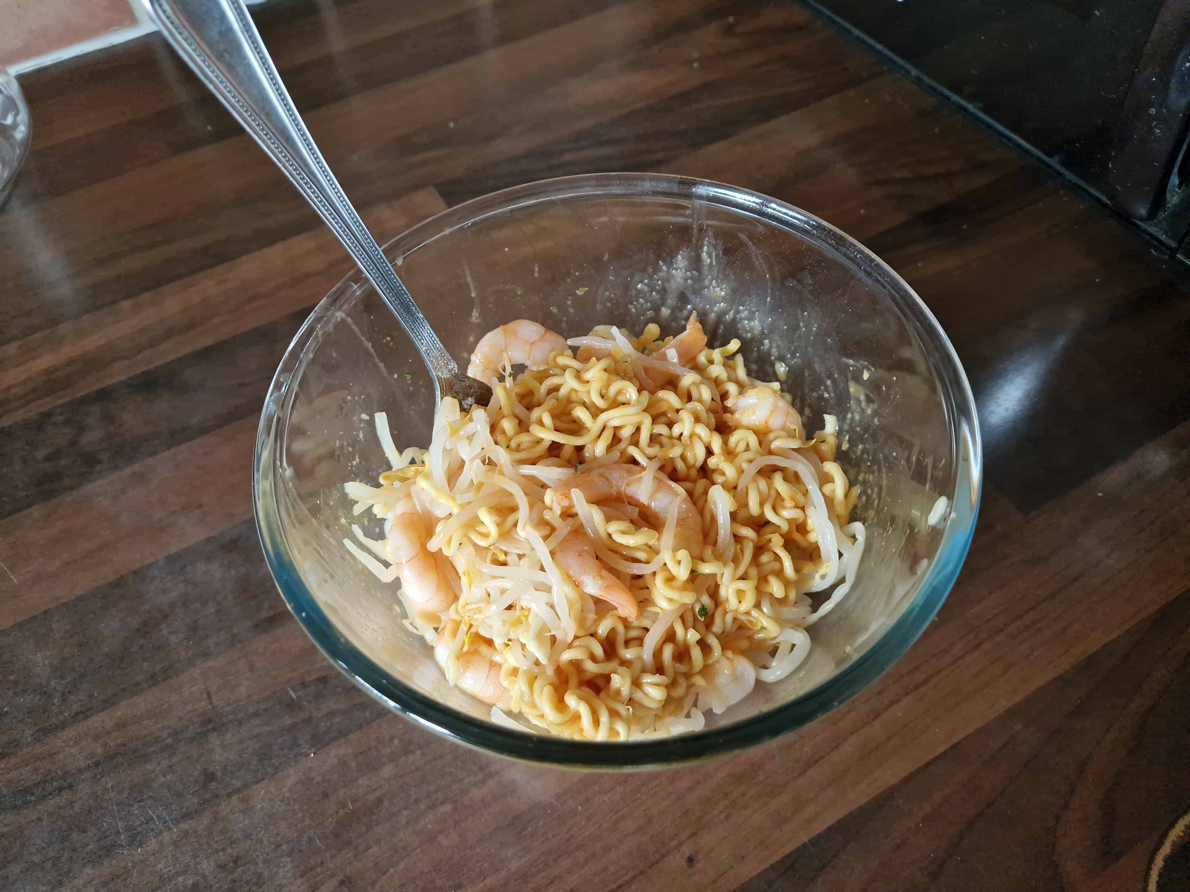 The prepared bowl of noodles, with prawns and bean sprouts.